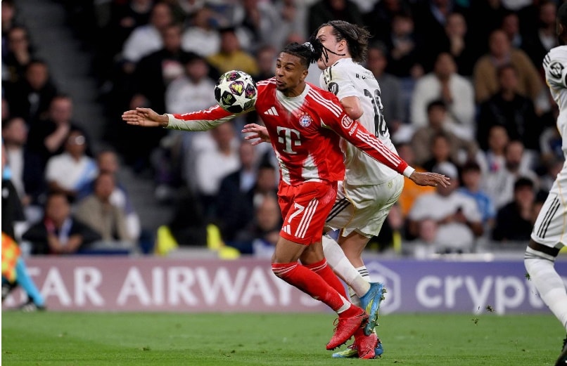 Michael Olise thực hiện pha đi bóng kỹ thuật trước sự áp sát của hậu vệ Alvaro Carreras bên phía Real Madrid.