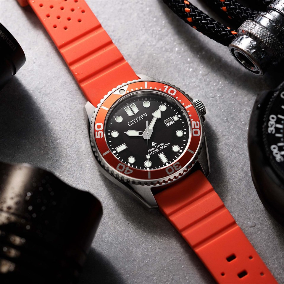 Đồng hồ lặn Citizen Promaster Marine BN0268-01E với mặt số đen, vòng bezel cam và dây đeo màu cam.