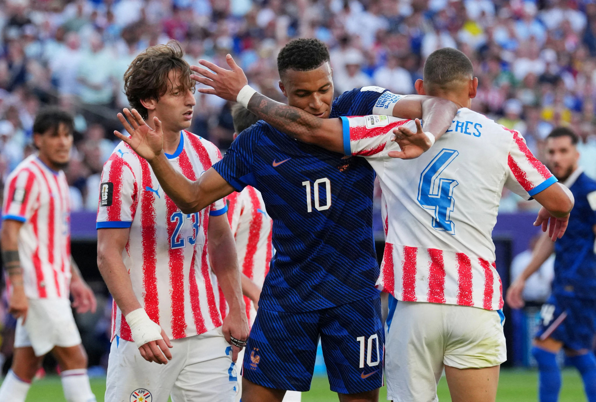 Mbappe bị các cầu thủ Paraguay vây ráp và phạm lỗi