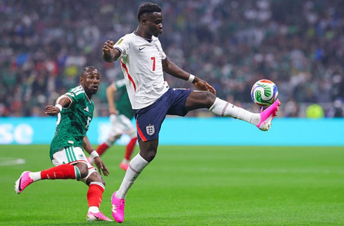 Bukayo Saka nỗ lực đi bóng trước sự áp sát của các cầu thủ Mexico