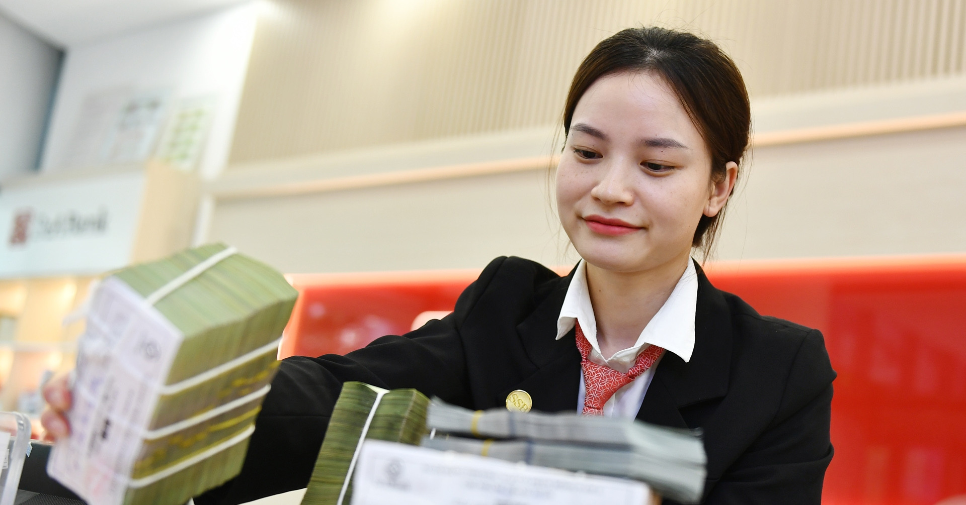 Khách hàng giao dịch gửi tiền tại quầy ngân hàng