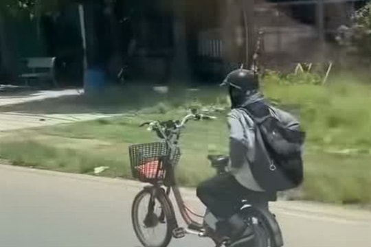 Nam sinh đi xe đạp điện buông hai tay trên quốc lộ